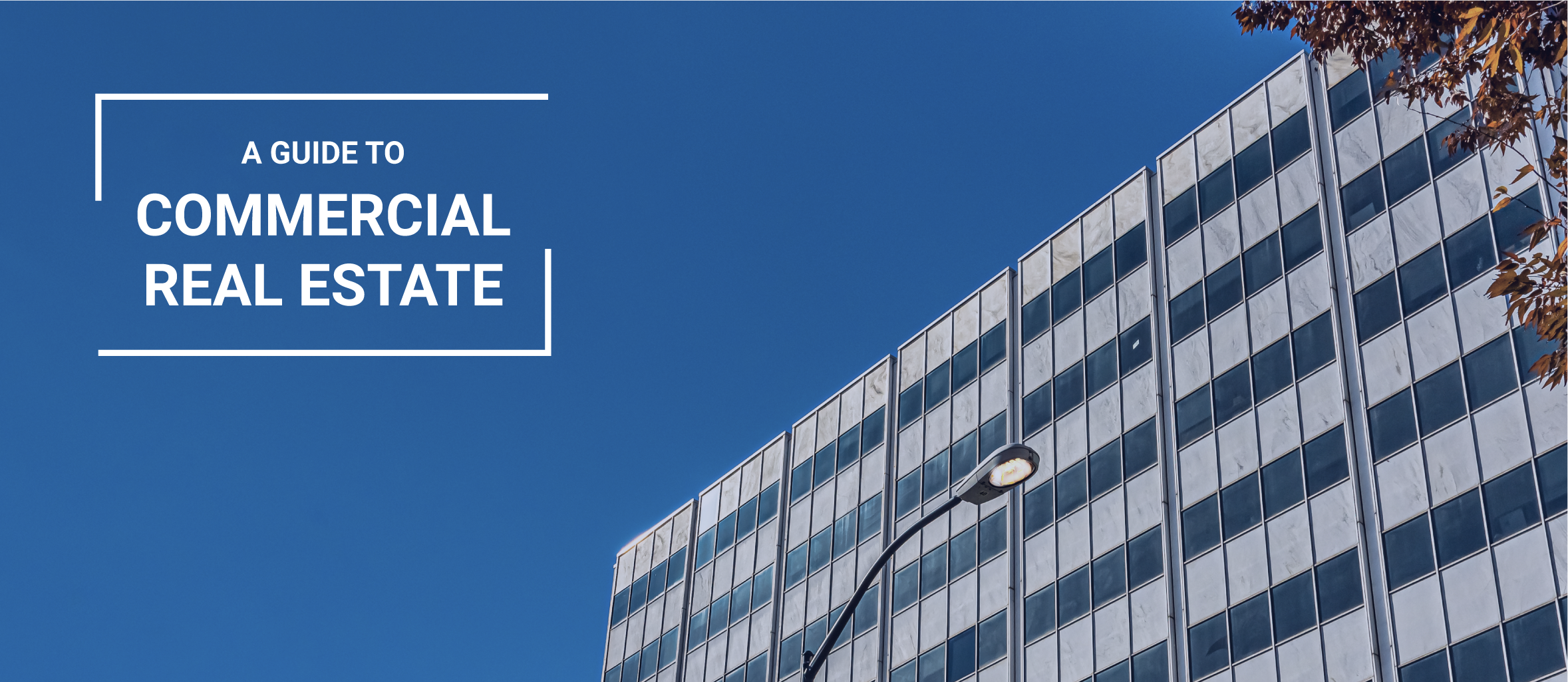 The top half of a commercial building with a blue sky behind it. To the left reads the words "A GUIDE TO COMMERCIAL REAL ESTATE"